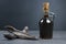 Glass bottle of carob molasses and carob pods on rustic background, locust bean healthy food