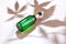 Glass Bottle of CBD or THC Oil with Hemp or Medical Cannabis Plant Leaves on beige Background with hemp leaves shadow