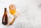 Glass and bottle of craft lager beer with opener on stone kitchen table background. Top view. Space for text