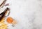 Glass and bottle of craft lager beer with raw wheat and opener on stone kitchen table background. Space for text. Top view