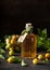 A glass bottle of delicious yellow plum liqueur or wine on wooden table.