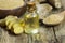 Glass bottle of essential ginger oil, ginger root and powder on wooden rustic background