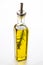 A glass bottle filled with high quality olive oil with a stem of rosemary inside on a kitchen counter waiting for a chef to use it