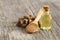 Glass bottle of Galangal essential oil, root and galanga powder in wooden spoon on rustic tabl