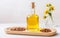 Glass bottle with jojoba oil and seeds on white wooden table soft light