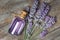 Glass bottle of Lavender essential oil with fresh lavender flowers on wooden rustic table