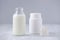 Glass bottle of milk and powder on gray background