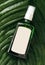 Glass bottle with shampoo or cosmetics product on palm leaves, tropical backdrop. Beauty skin care product template. concept of