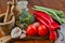 Glass bottle with spices, cork bottle, olive wood mortar, red and green vegetables, broccoli, tomatoes, garlic, onion