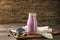 Glass bottle of tasty blueberry smoothie on wooden table
