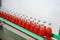 Glass bottled red juice on steel conveyor of production line in beverage processing factory