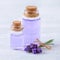 Glass bottles aroma oil and fresh lavender flowers on wooden table