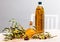 Glass bottles and carafes with fresh olive oil on wooden table with olive branches and fresh olives