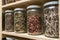 Glass bottles with colorful spices on the shelfs