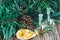 Glass bottles of essential oil with pine cones, oranges and fir branches on wooden background