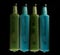 Glass bottles filled with blue and green thick liquid showing bubble formation