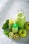 Glass bottles with green smoothies made with green fruits. Detox and healthy diet background