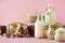 Glass bottles of vegan plant milk and almonds, nuts, coconut, hemp seed milk on pink background. Banner with copy space. Dairy