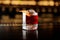 Glass of a Boulevardier cocktail with orange zest on the steel and wood bar counter