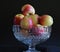 Glass bowl with apples, dark background