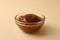 Glass bowl with caramel condensed milk on beige background