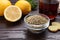 Glass bowl of dry tea and lemon on wooden table, closeup with space for text. Natural cough remedies