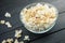 Glass bowl with freshly popped popcorn with salt on dark wooden