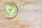 Glass bowl full of granny smith apple slices on a butcher block table, and mesh tray ready for dehydrating apples