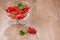 Glass bowl full of red currant/glass bowl full of red currant on a wooden background. With copy space