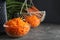 Glass bowl with grated carrot on grey table, closeup