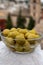 Glass bowl with green andalusian olives served on outdoor terrace with view on old part of Granada, Andalusia, Spain