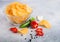 Glass bowl plate with potato crisps chips with chilli pepper on light table background. Red and green chilli pepper with garlic