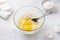 Glass bowl with soaked semolina, eggs and a bowl of sugar. cooking mannik, cake or pie on a light blue background. step