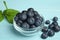 Glass bowl of tasty blueberries on color wooden