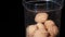 Glass bowl of tasty walnut shaped cookies with boiled condensed milk in dark room.