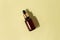 glass brown bottle with pipette with essential oil on a pastel green background top view. Aromatic cosmetic product for skin and