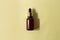 glass brown bottle with pipette with essential oil on a pastel green background top view. Aromatic cosmetic product for skin and