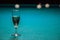 A glass of champagne is on the pool table. the winner of the game, the champion drinks a glass of sparkling wine. Hobbies, sports