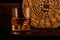 Glass chilled whiskey with ice cubes on wooden background in cellar