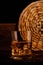 Glass chilled whiskey with ice cubes on wooden background in cellar