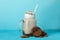 Glass of chocolate milkshake, cookies and almond on blue background