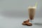 Glass of chocolate milkshake, cookies and cinnamon on gray background