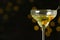 Glass of Classic Dry Martini with olives on blurred background
