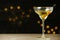 Glass of Classic Dry Martini with olives on grey table against blurred background.