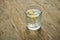 Glass of clear water with lemon on a wooden background. Pure water concept