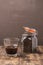 Glass of cofee with cofee beans. Selective focus. Cup of black coffee in a glass and grains in a glass jar on a wooden table