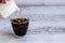 Glass with coffee and ice cubes on wodden table.