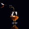 glass with cognac on a black background