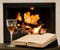 Glass of cognac and book by the fireplace