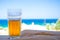 Glass of cold beer on blurred aegean sea background.